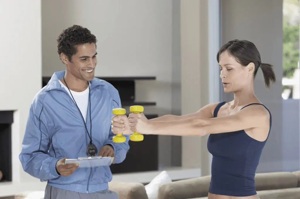 A man and woman holding yellow dumbbells in their hands.