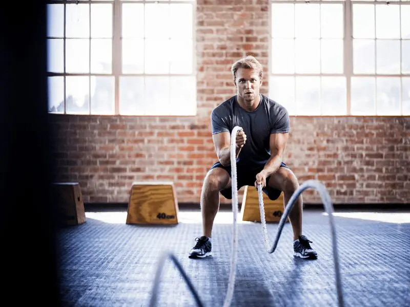 A man is holding a rope in the gym