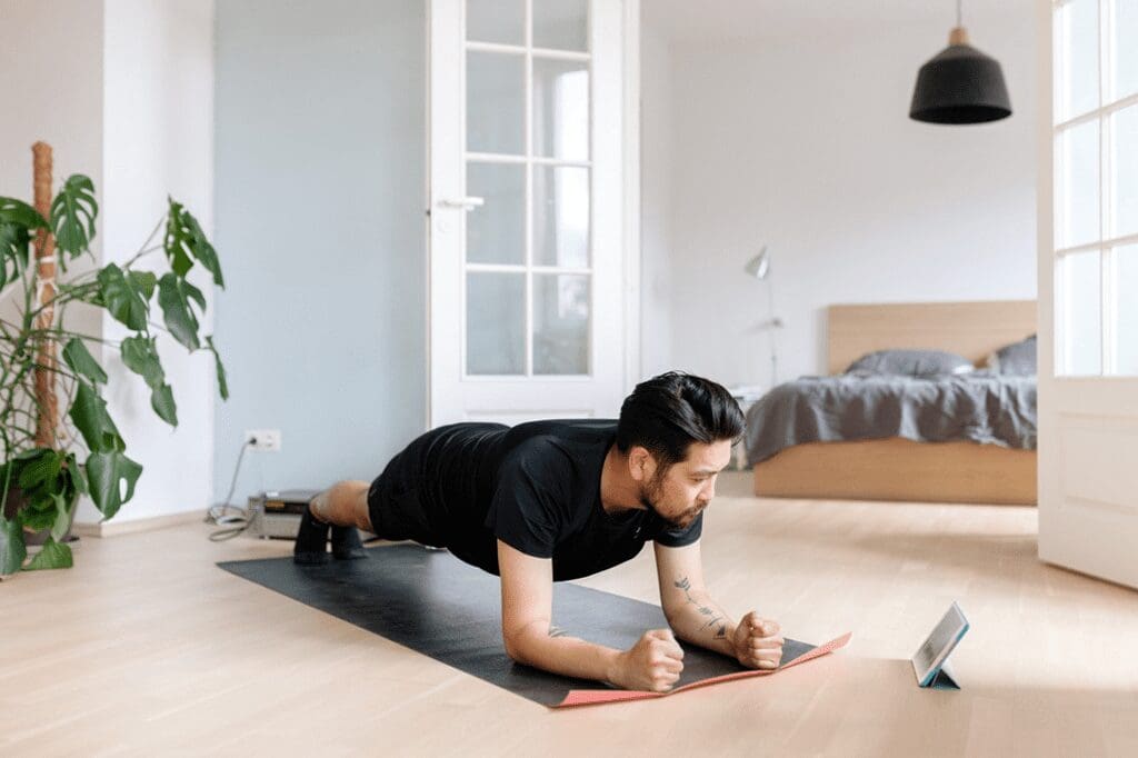 A man is doing plank exercises in his living room.