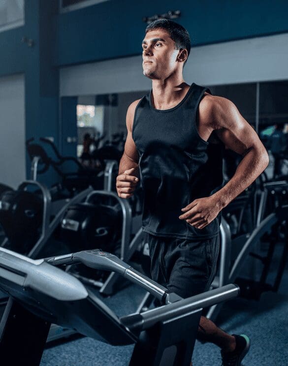 A man in black shirt running on a treadmill.