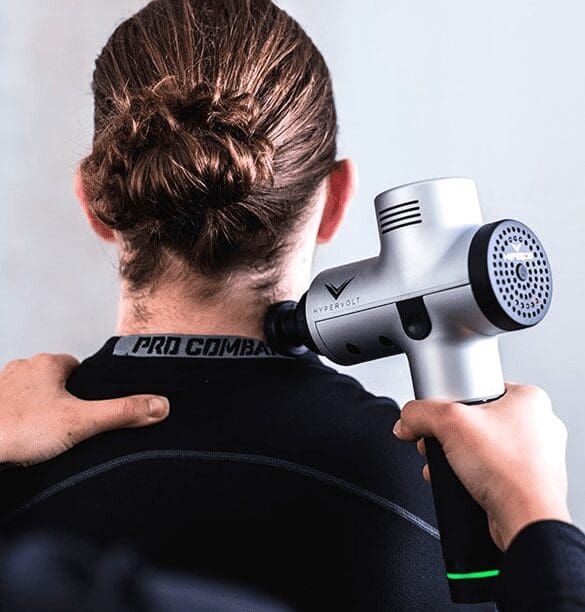 A person holding an electric hair dryer on their shoulder.
