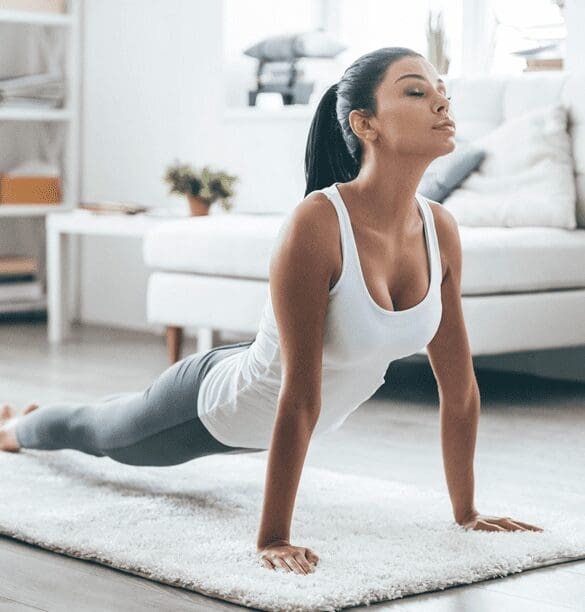 A woman is doing yoga in her living room.
